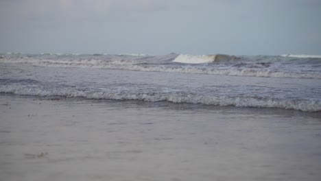 Super-Zeitlupenaufnahme-Von-Kleinen-Wellen,-Die-Während-Der-Grauen-Abenddämmerung-Nach-Sonnenuntergang-Am-Strandufer-Rollen-Und-Brechen