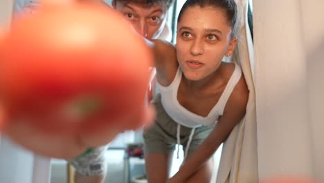 pareja buscando comida en el refrigerador