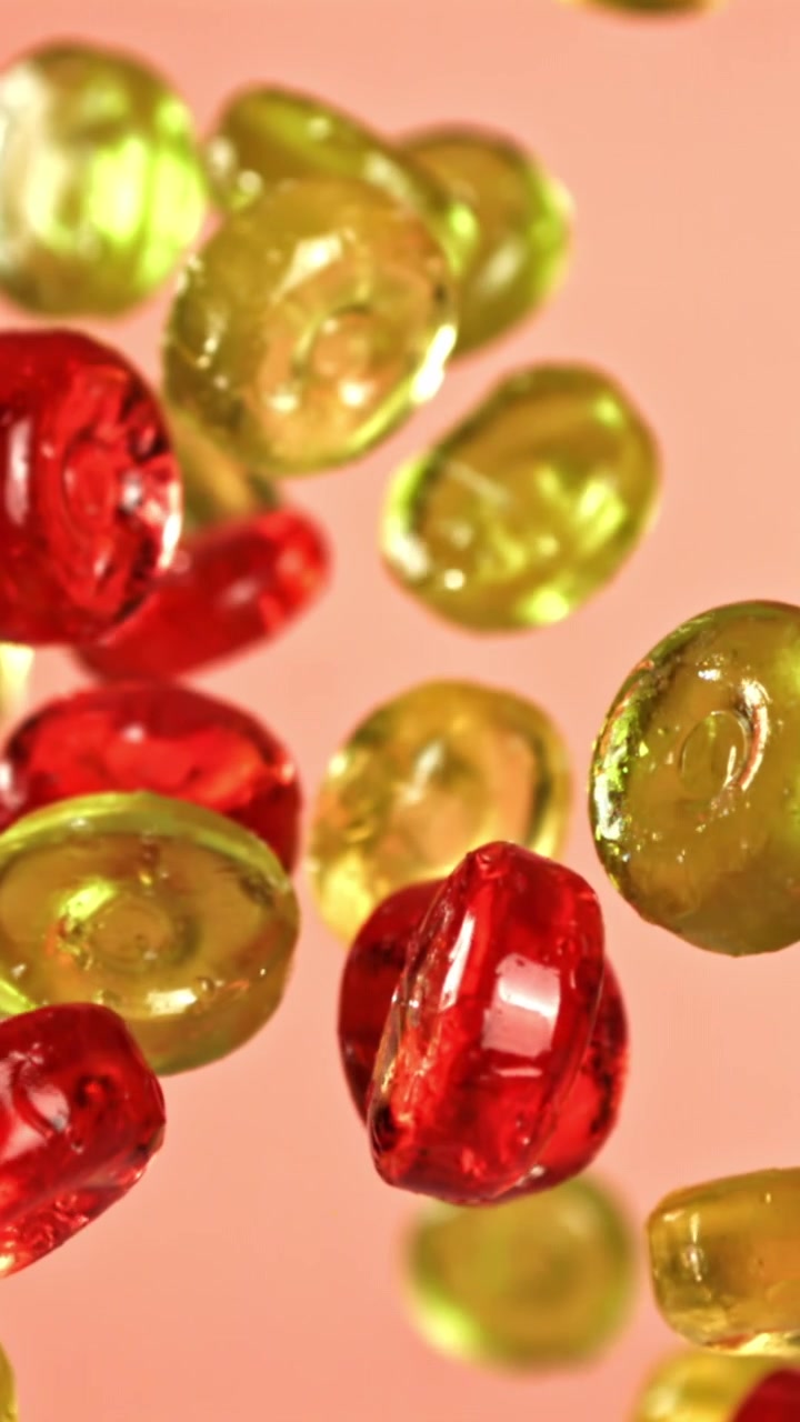Caramelle Colorate che Galleggiano Verso l'Alto su Sfondo Pesca
