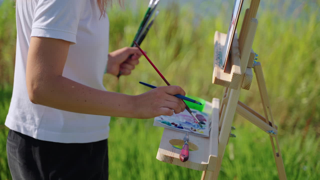 Woman painting outdoors with easel