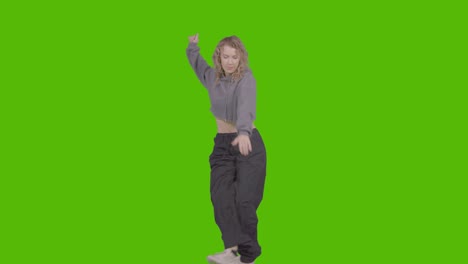 studio shot of young woman having fun dancing against green screen 37