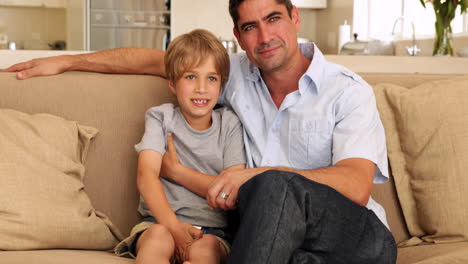 padre e hijo viendo la televisión juntos en el sofá