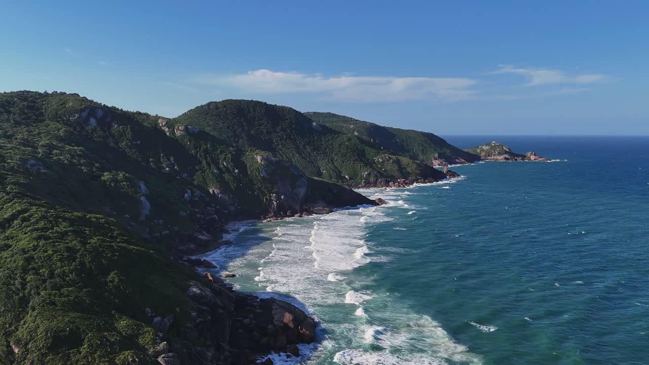 Splendida ripresa aerea della costa rocciosa vicino a Florianópolis, in Brasile, con onde oceaniche, scogliere e cielo blu che creano un bellissimo paesaggio costiero