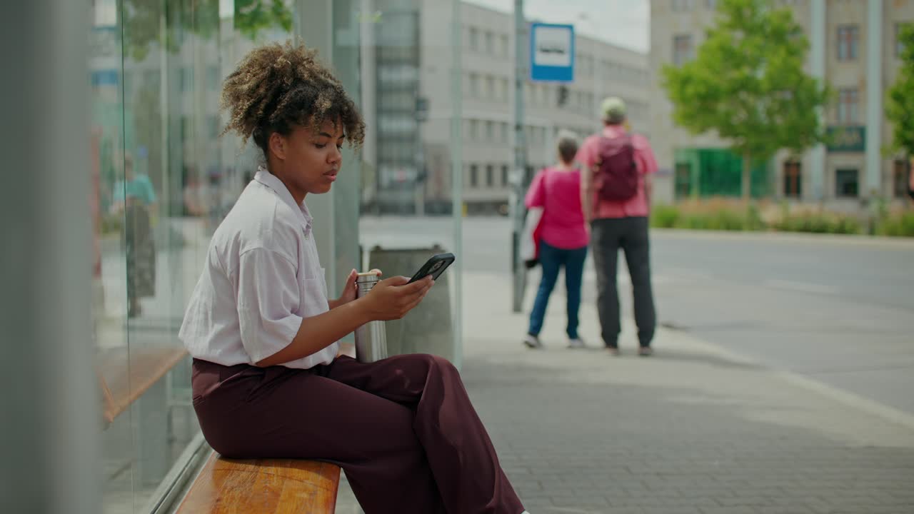 Woman using smartphone at bus stop
