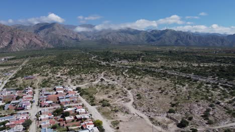 flyover pulls back from cafayate town in mtn plateau of argentina