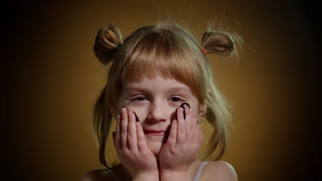 portrait of teen child kid smears face with melted dark chocolate and starts eating chocolate bar