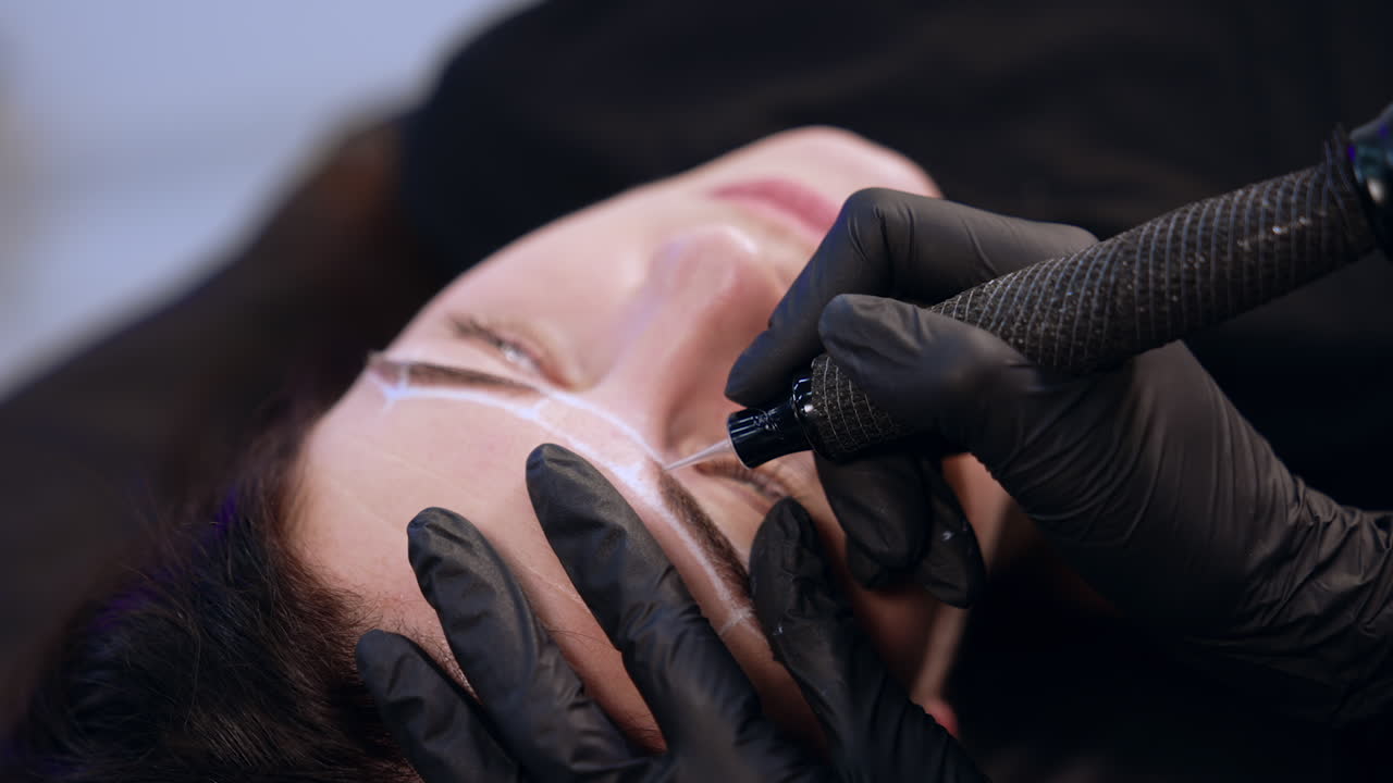 Permanent make up instrument held in the gloved hand of a brow master. Cosmetology and beauty concept.
