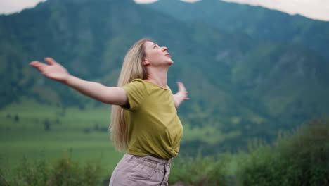 Cheerful-woman-spins-around-over-large-valley-against-hills