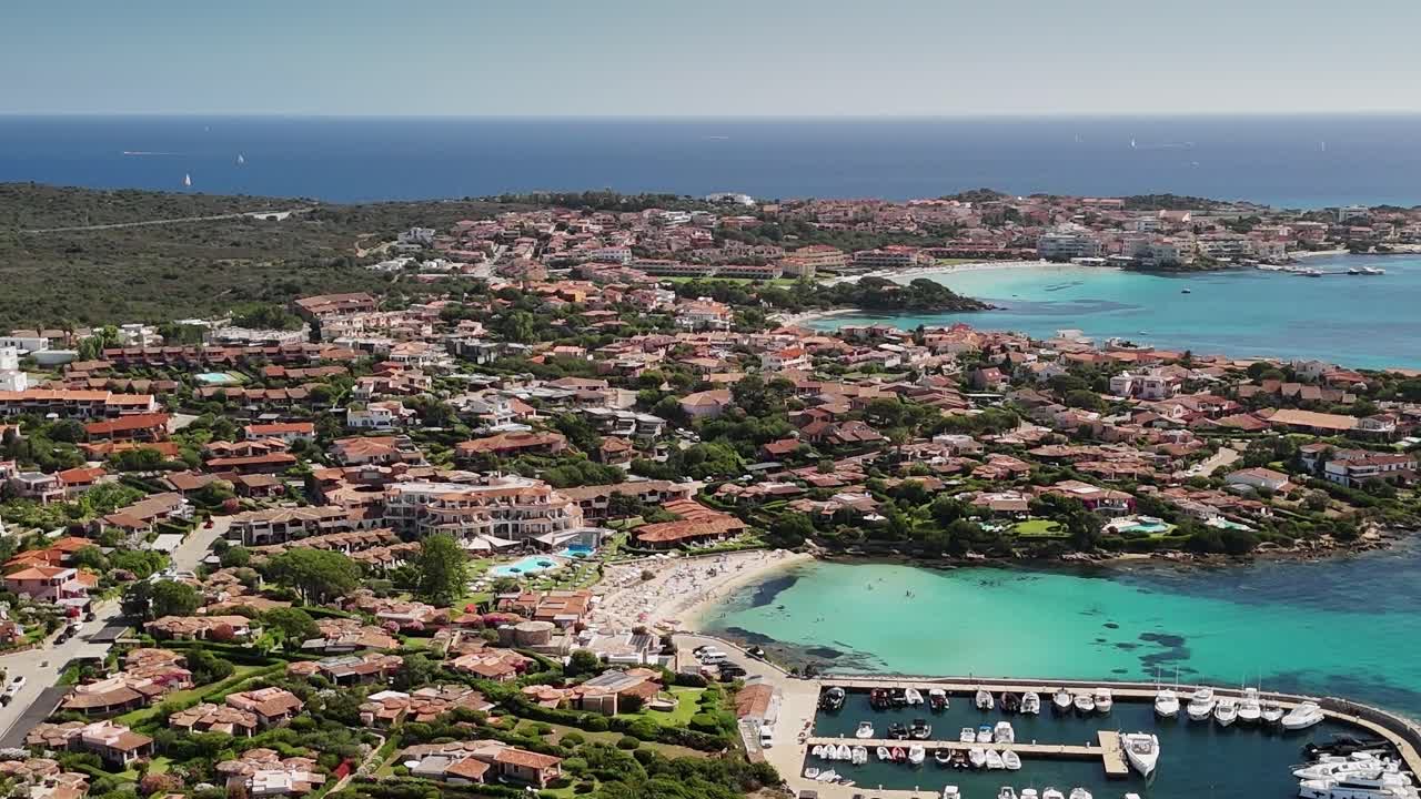 Vista della costa sarda con case, barche e acque cristalline in estate