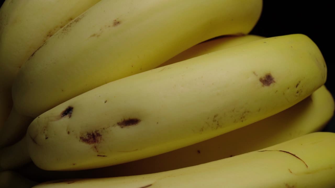 검정색 배경에 있는 노란색 바나나 무리의 오른쪽 팬을 닫으세요.