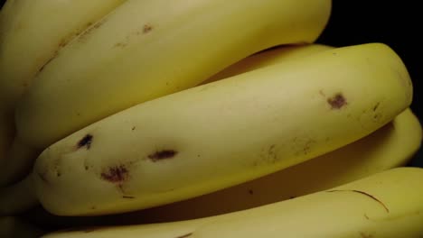 primer plano a la derecha del racimo de plátano amarillo sobre fondo negro