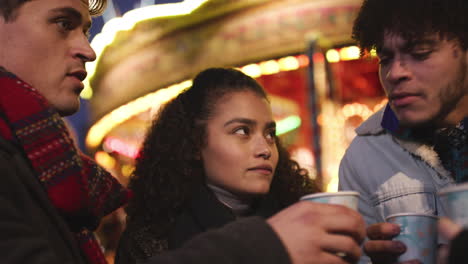 group of friends drinking mulled wine at christmas market