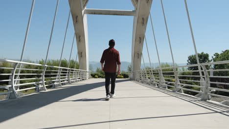 young man crossing bridge