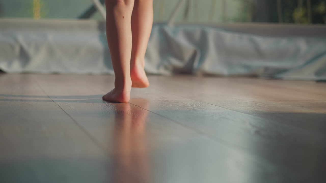 어린이의 발은 관광 텐트의  벽을 향해 움직입니다. 맨발의 소년은 가운 창문 근접 속도 느린 모션에 접근합니다. 작은 관광객은 흐릿한 배경에 반이는 장소에서 휴식을 취합니다.