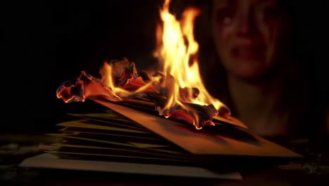 intense moment of despair as personal letters ignite into flame, capturing the emotional turmoil of loss and burning memories in a dark setting