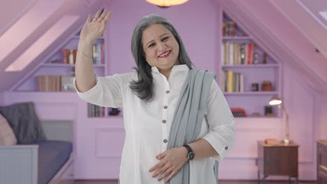 madre india feliz diciendo hola y agitando la mano