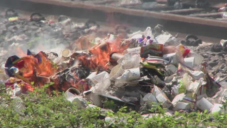 montones de basura en llamas cerca de las vías del tren