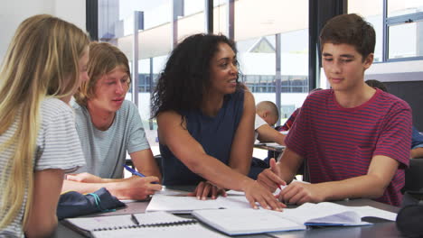 Lehrer-Studiert-Schulbücher-Im-Unterricht-Mit-High-School-Kindern