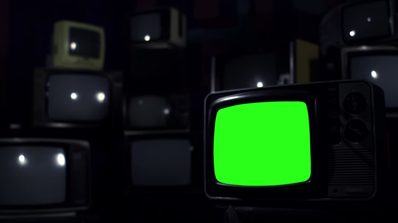 Televisore d'epoca che si accende e si spegne con schermo verde e barre colore. Tonalità blu scuro. Zoom avanti.