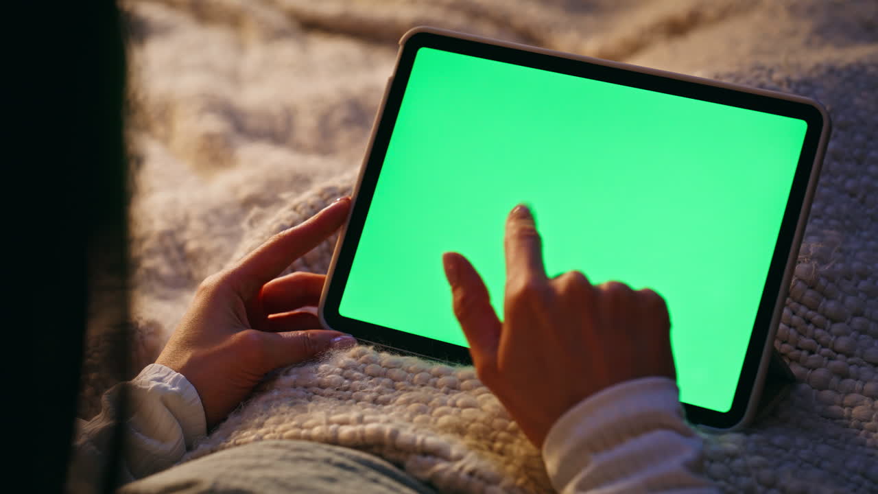 Finger scrolling mockup tablet browsing social media in dark bedroom closeup