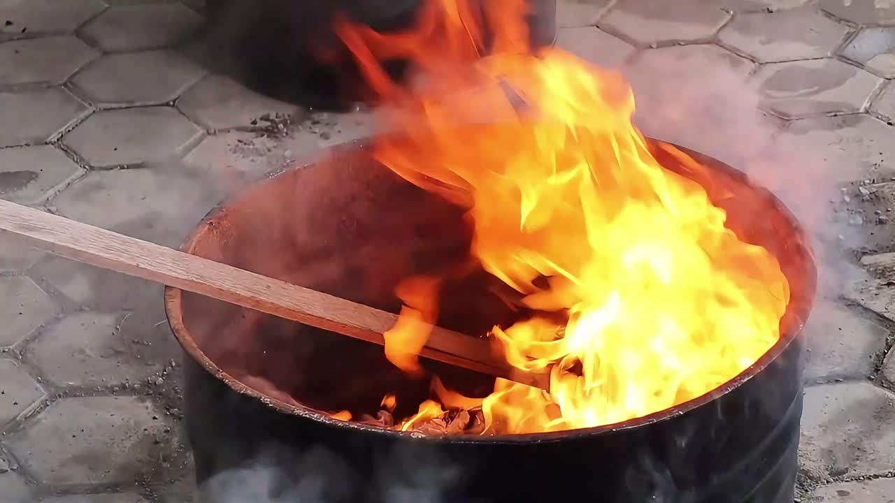 중국의 신년절에 선조를 배하고 종이 금을 태우고, 드럼 안에서 빨간색으로 불타는 불.
