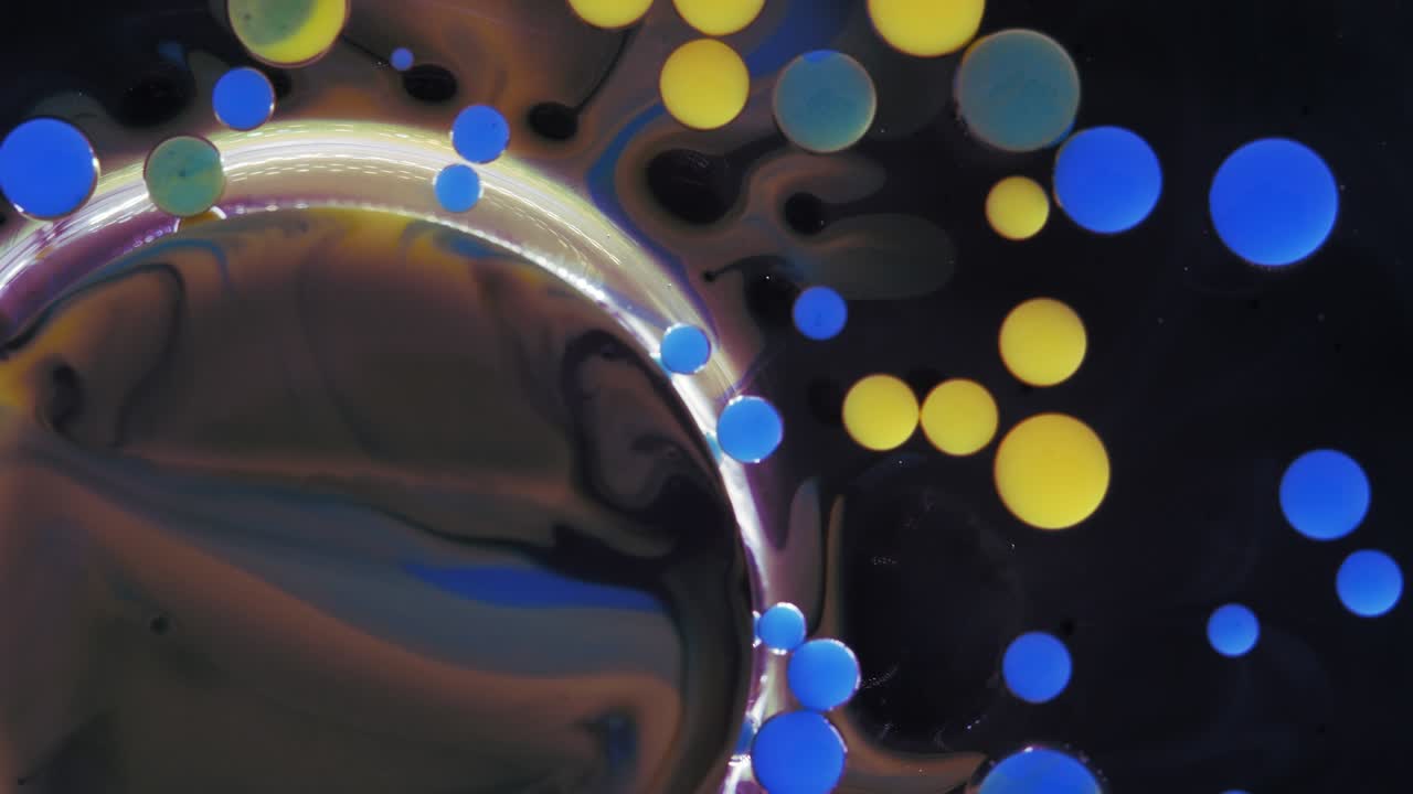 burbujas coloridas. mezcla abstracta de amarillo y azul sobre un fondo negro. fondo de pintura de color artístico.