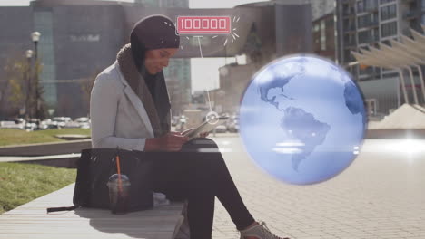 globo y múltiples iconos digitales flotando sobre una mujer en hijab usando una tableta digital en la calle