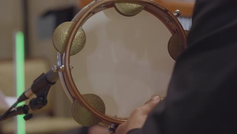 close up, male artist playing percussion shakers bells tabla طبلة د?