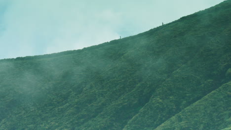 cinematic dramatic long lens shot of two joggers making their way down a ridge