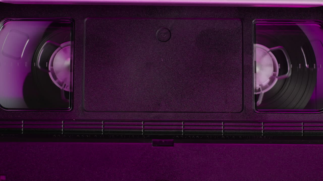 VHS PLAYER, Old video recorder inside in neon pink light close-up, VHS. Retro player in neon blue light, vintage video cassette broadcasting, audio tape.
