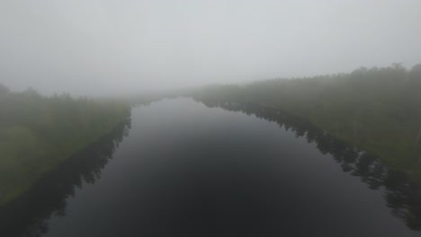 Drone-flight-over-a-fogy-lake-in-Dals-Ed,-Sweden