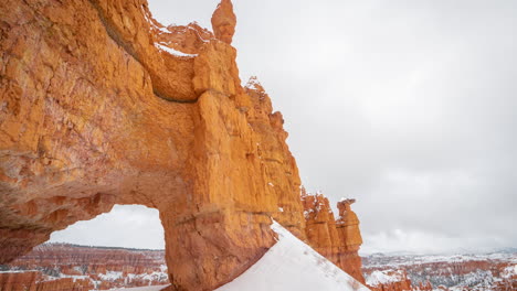 Bryce-Canyon-National-Park-Utah-Usa,-Lapso-De-Tiempo-De-Nubes-Moviéndose-Sobre-Formaciones-Rocosas-Cubiertas-De-Nieve-Y-Arco-Natural