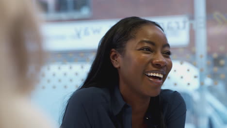 Laughing-African-American-Businesswoman-Sitting-At-Table-In-Office--Meeting-Room