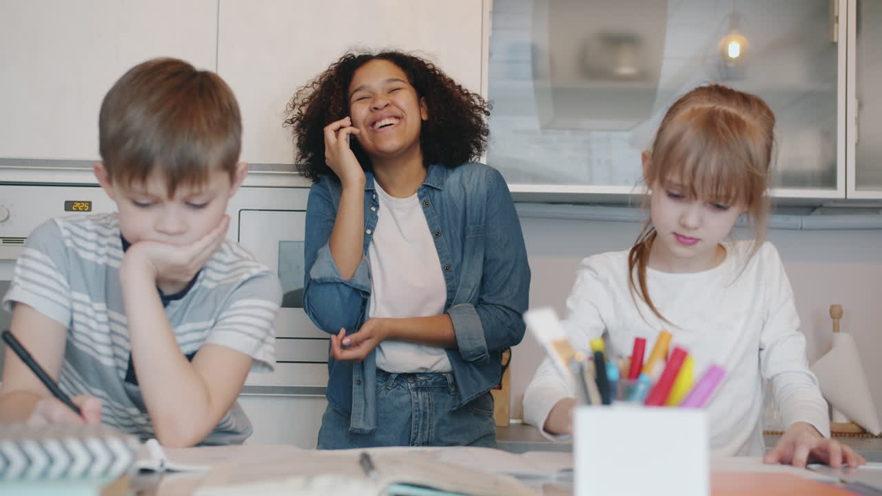 Bambini che fanno i compiti e conversano in cucina