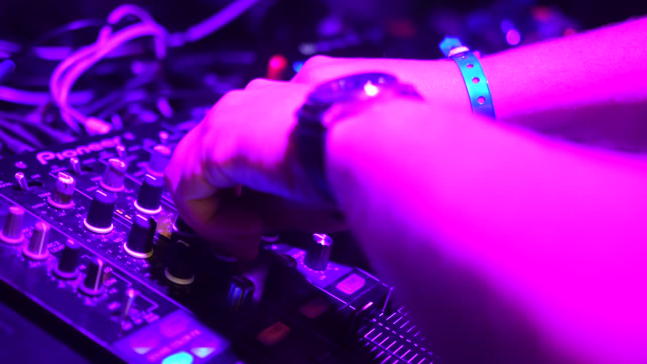 las manos del dj ajustan varios controles de pista en la cubierta del dj
