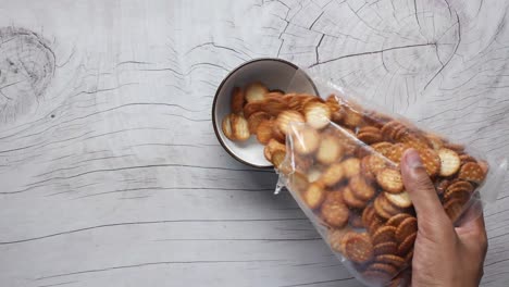 pouring crackers into a bowl