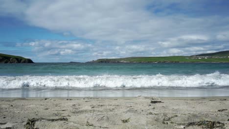 Wellen,-Die-Den-Sandstrand-Mit-Blauem-Himmel-Und-Inseln-Umspülen