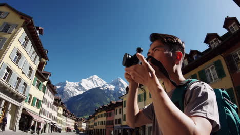 man taking pictures in a picturesque town