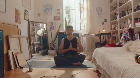 young man practicing yoga meditation at home