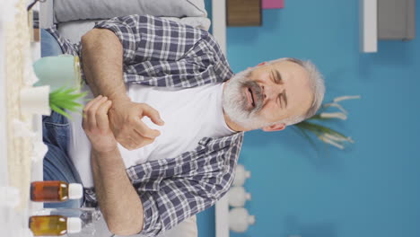 video vertical de un anciano con dolor en la muñeca.