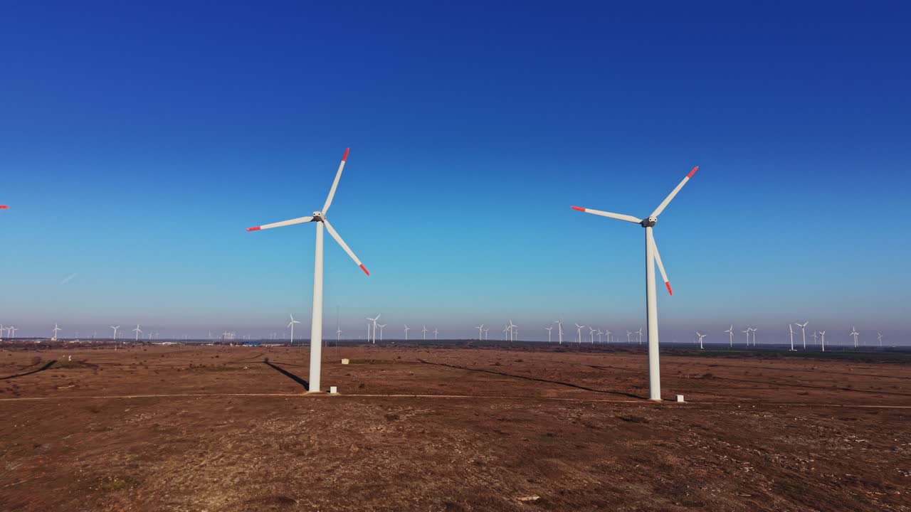 Turbine eoliche su un paesaggio piatto con un cielo blu limpido