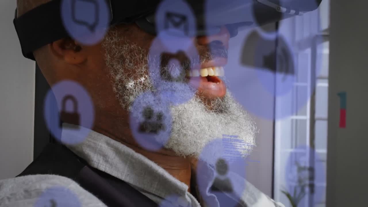 múltiples iconos digitales azules contra afroamericano hombre de negocios de alto nivel que usa auriculares vr en la oficina