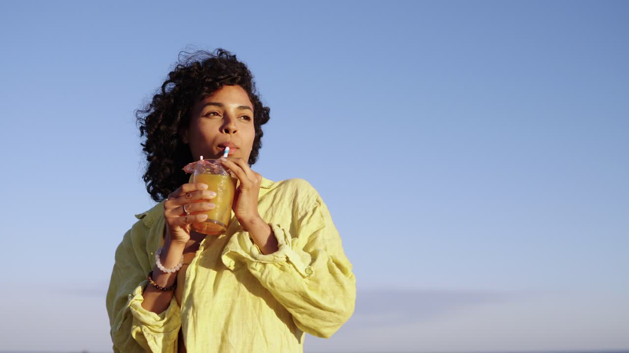 Woman enjoying a refreshing drink at the beach