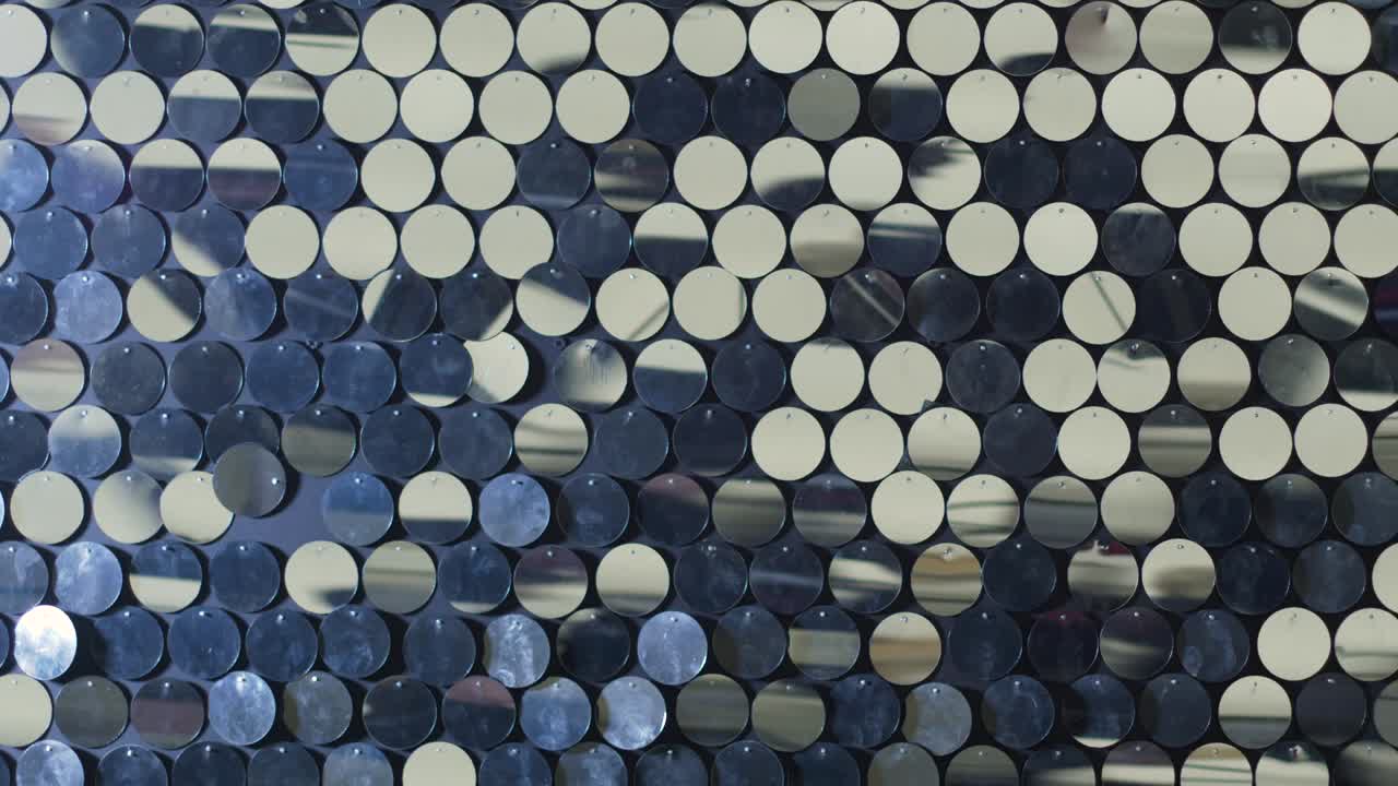 círculos de espejo reflectantes de plástico colgados en la pared y vibrando