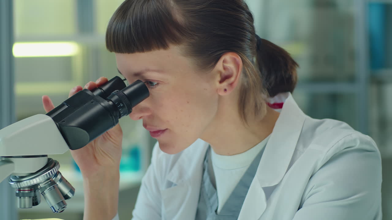 Scienziata al lavoro con il microscopio
