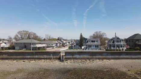 dramatic aerial footage of pullback through seawall, and then elevating to show surrounding neighbourhood