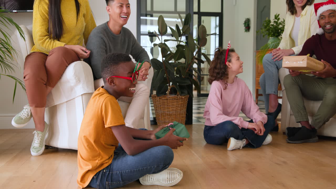 Diverse family exchanging gifts at home, celebrating Christmas with joy and laughter
