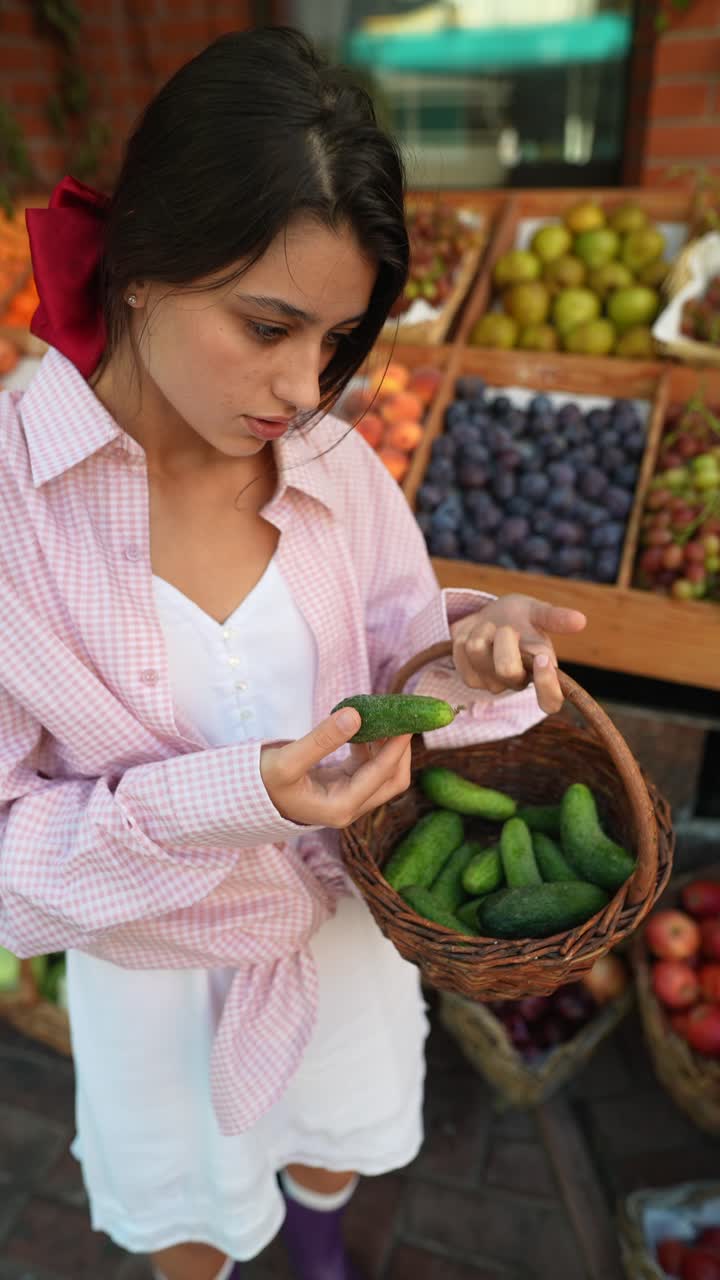 mujer comprando pepinos en un mercado de agricultores
