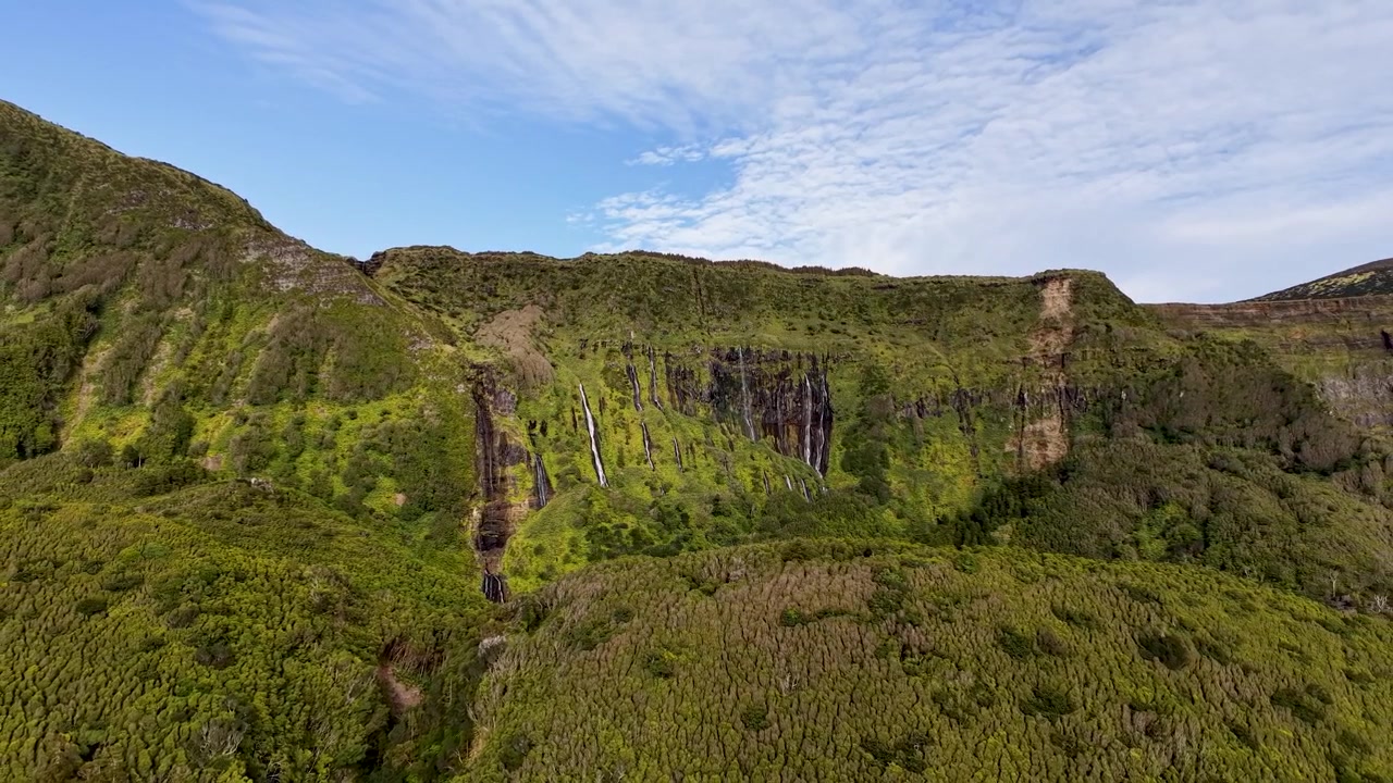 Ampio paesaggio panoramico di cascate che scorrono attraverso lussureggianti scogliere vulcaniche a Poço da Ribeira do Ferreiro nelle Azzorre, Portogallo