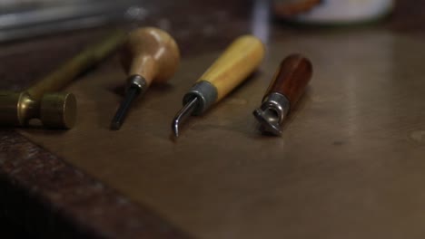 tools in a custom jeweler's shop on a wooden table used for carving and molding clay